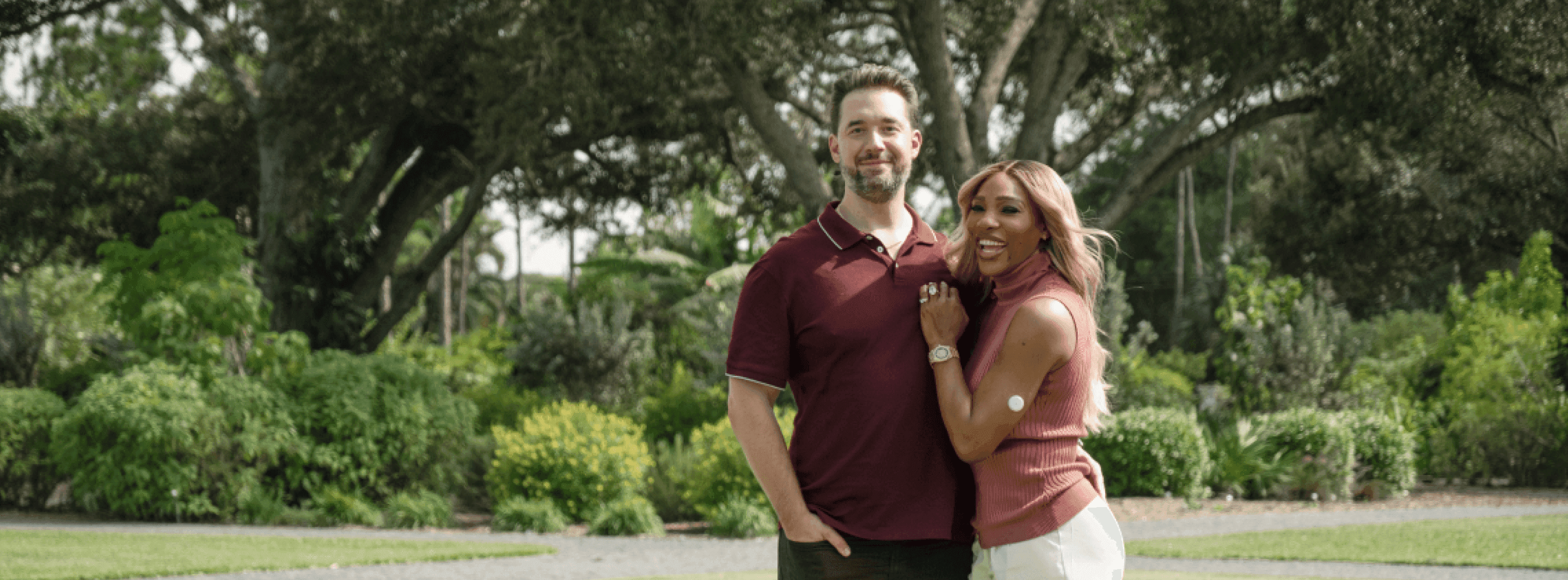A photograph of Serena Williams and Alexis Ohanian standing together in a grassy field. 